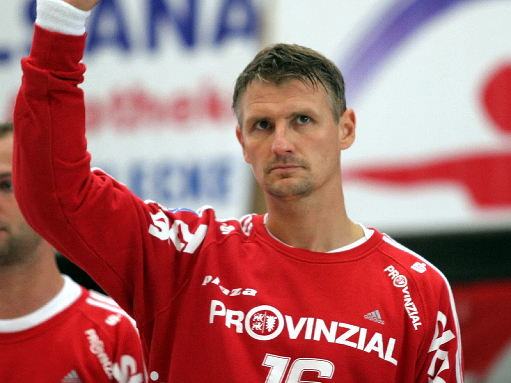 Peter Gentzel i THW Kiels röda målvaktströja med nummer 16 lyfter handen mot publiken